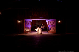 Bride and Groom at barn wedding venue with purple lighting
